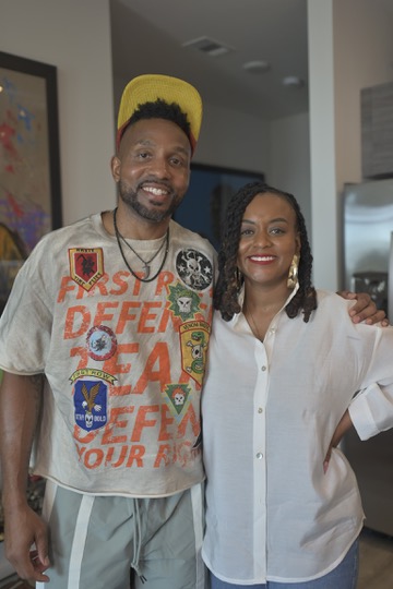 Host posing with a guest in white